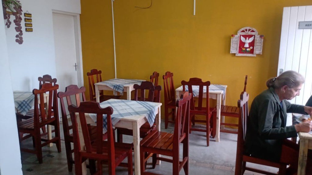 Refeitório com mesas e decoração de fé