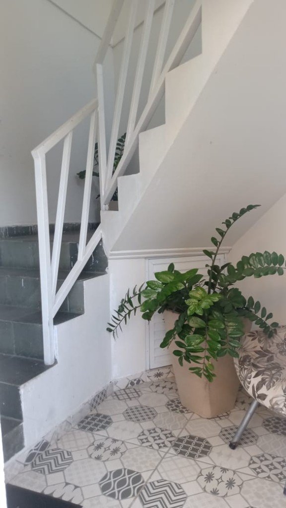 Hall com escada e plantas decorativas